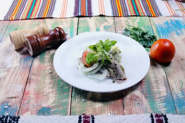 Pork steak with tomatoe, salt and pepper, wooden background