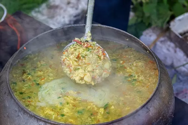 Porridge in a large cauldron over an open fire