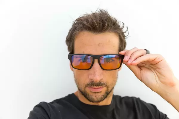 Portrait of a man wearing the gaming glasses by Horus X made to filter blue light and make gaming marathons more bearable for the eyes of a gamer