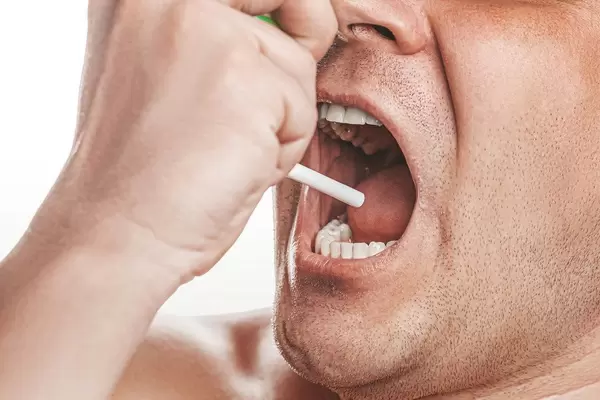 Portrait of a sick man sprays therapeutic aerosol in the oral cavity