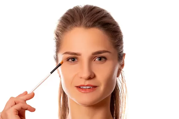 Portrait of a woman with makeup brush near her eyes