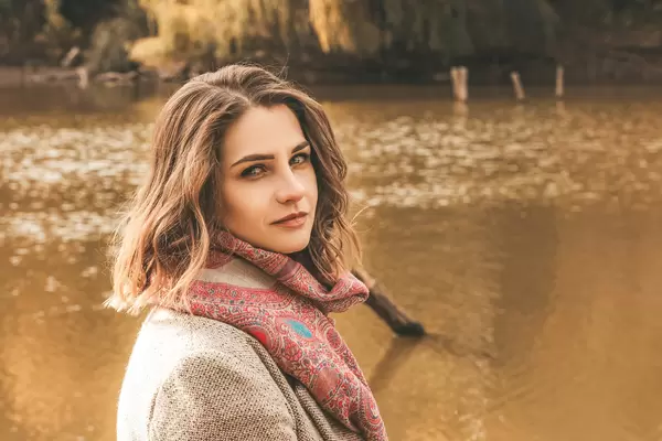 Portrait of a young woman on the background of a pond