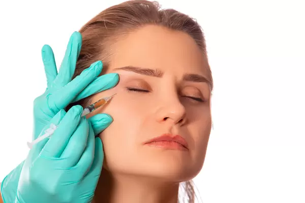 Portrait of attractive young woman getting cosmetic injection