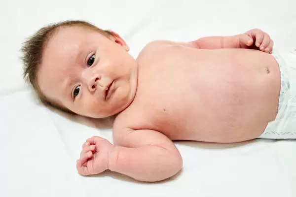 Portrait of cute adorable baby boy lying on bed