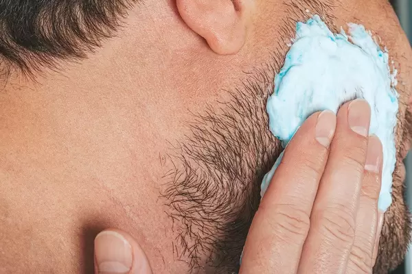Portrait of male putting shaving foam on his beard. Skin care concept (Flip 2019)