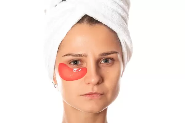 Portrait of young woman with red cosmetic patch under one eye