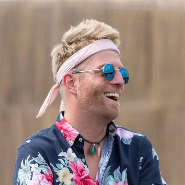 Portrait von Festivalbesucher in buntem Hippie-Look mit John-Lennon-Sonnenbrille am Tomorrowland