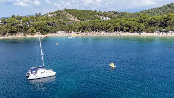 Postcard from Greece: sailing boat and pedal boat in front of Koukounaries beach on Skiathos