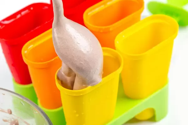 Pour a spoon of homemade ice cream into an ice cream mold
