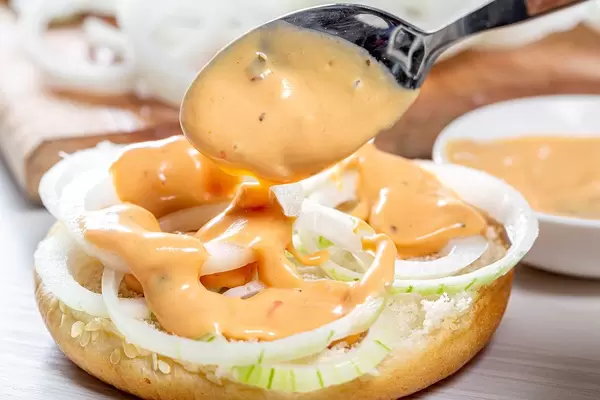 Pour the sauce on top of onions on a Burger bun