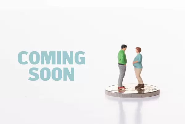 Pregnant woman and man standing on 2 Euro coin with Coming Soon text