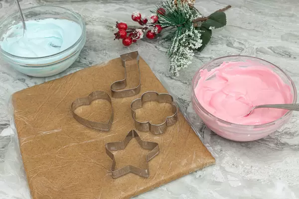 Preparing Christmas cookies with cookie templates and colorful creams