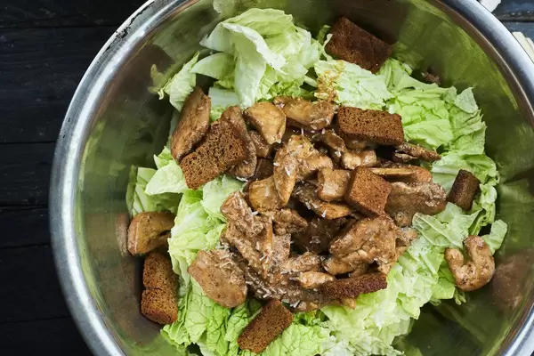 Preparing classic caesar salad