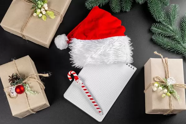 Preparing for Christmas with gifts Santa's hat, paper, and pen