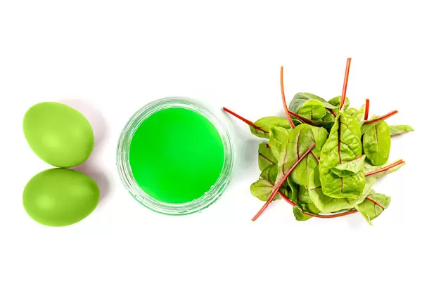 Preparing for easter, coloring eggs in green color with beet leaves