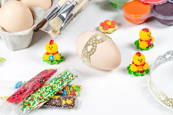 Preparing for the Easter holiday- eggs, decor and paints on white background (Flip 2020)