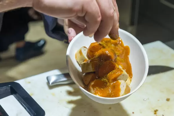Preparing German curry sausage with spices