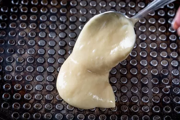 Preparing homemade waffles, pouring a dough