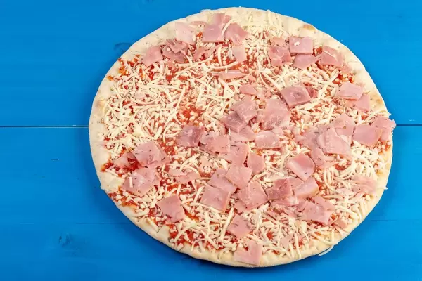 Preparing raw Pizza with Ham