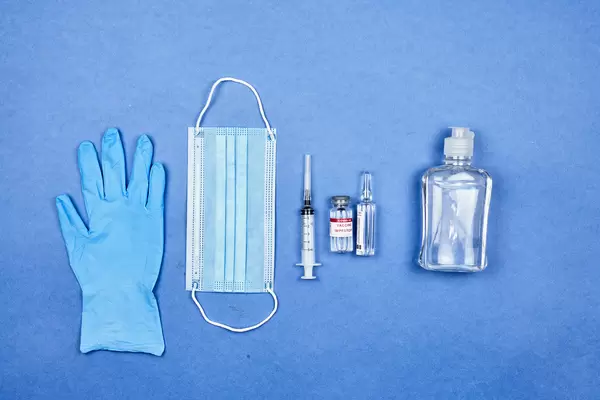 Preparing to vaccinate a patient. Protective medical gears and vaccine capsule with syringe