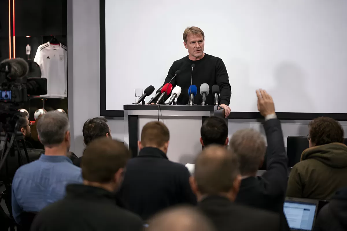 Pressekonferenz mit Sprecher am Rednerpult vor Journalisten