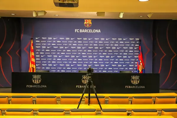 Pressezimmer mit gelber Sitzreihe für Journalisten und kleiner Bühne für Spieler und Mitarbeiter des FC Barcelona auf dem Camp Nou Gelände in Katalonien, Spanien