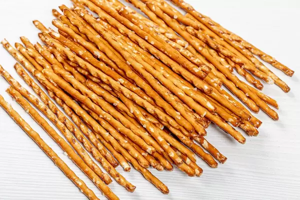 Pretzel sticks on white wood background