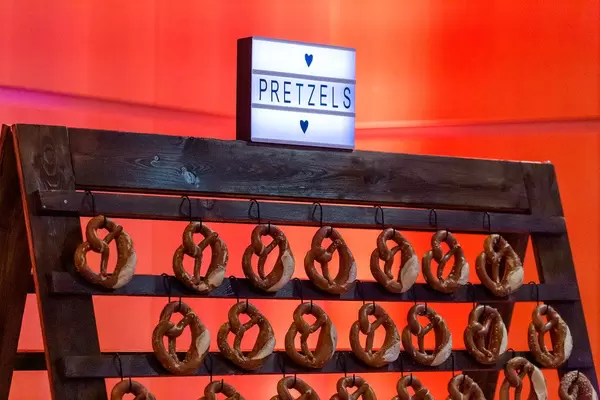 Pretzels on display: traditional German food on a wooden stand with lit sign
