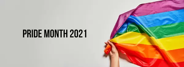 Pride month 2021 - LGBTQ+ activist holds a big rainbow flag