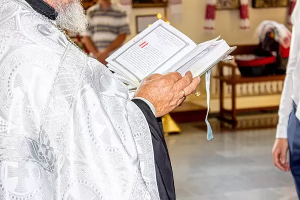 Priest holding a Bible in hands