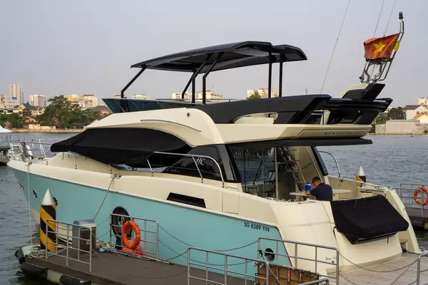 Private Yacht mit Sonnendeck und Vietnamesischer Flagge im Privat-Hafen von Vinhomes Central Park und Apartments in Ho Chi Minh Stadt, Vietnam
