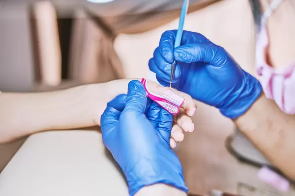 Professional manicurist master applying gel for nail extension