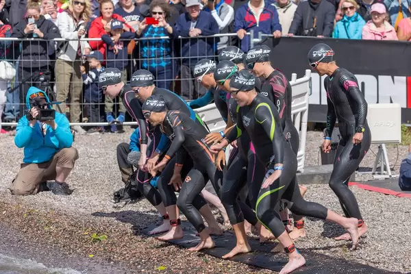 Professional sportswomen start with the women's group the swimming competition of the triathlon event Ironman 70.3 in lake Vesijärvi