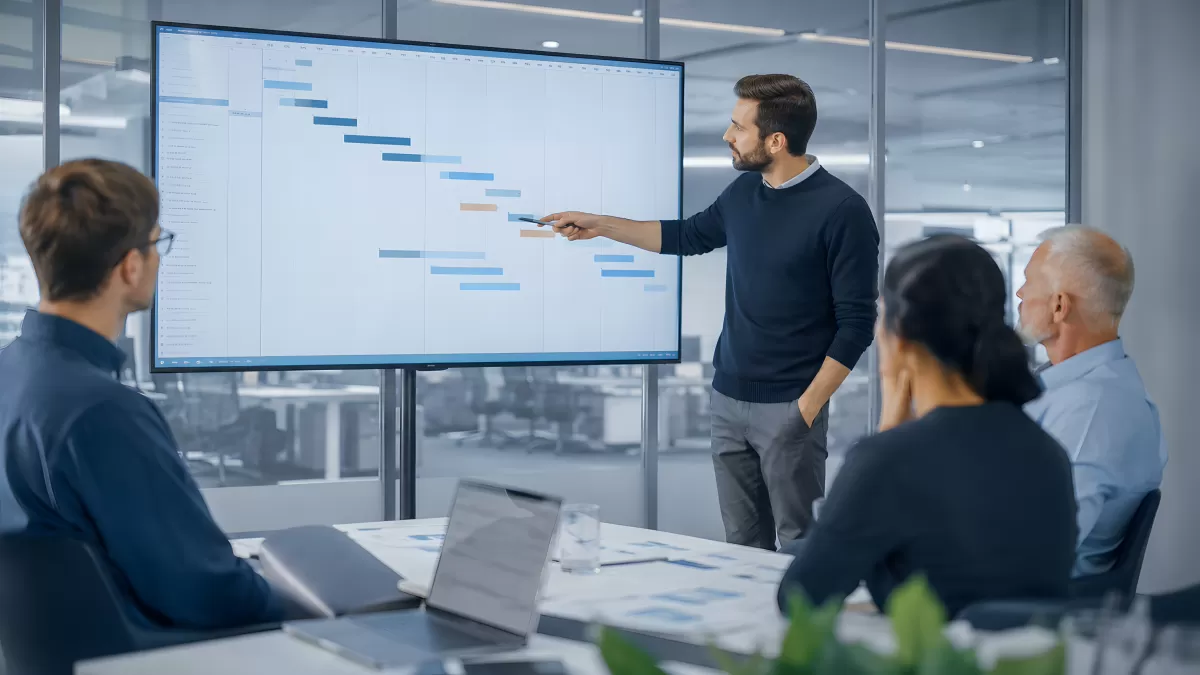 Projektmanager präsentiert Gantt-Diagramm im Meetingraum