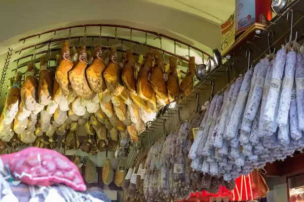 Proscciutto und italienische Trockensalami hängen von der Decke bei Antica Salumeria