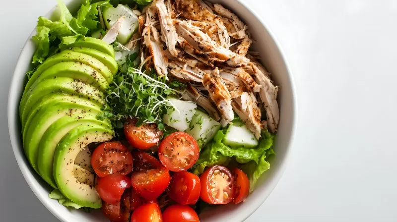 Proteinbowl mit Avocado Tomaten Gurke und Hähnchenstreifen