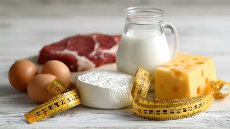 Proteinreiche Lebensmittel mit Maßband und Ei auf Holz