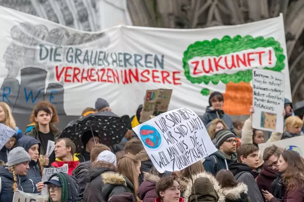 Protest gegen RWE mit dem Schild 'Die grauen Herren verheizen unsere Zukunft!'