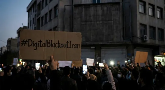 Protest-Menge bei Nacht mit Schildern und Smartphones