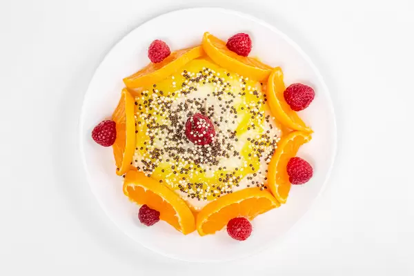Pudding with fresh mandarin and raspberries, top view