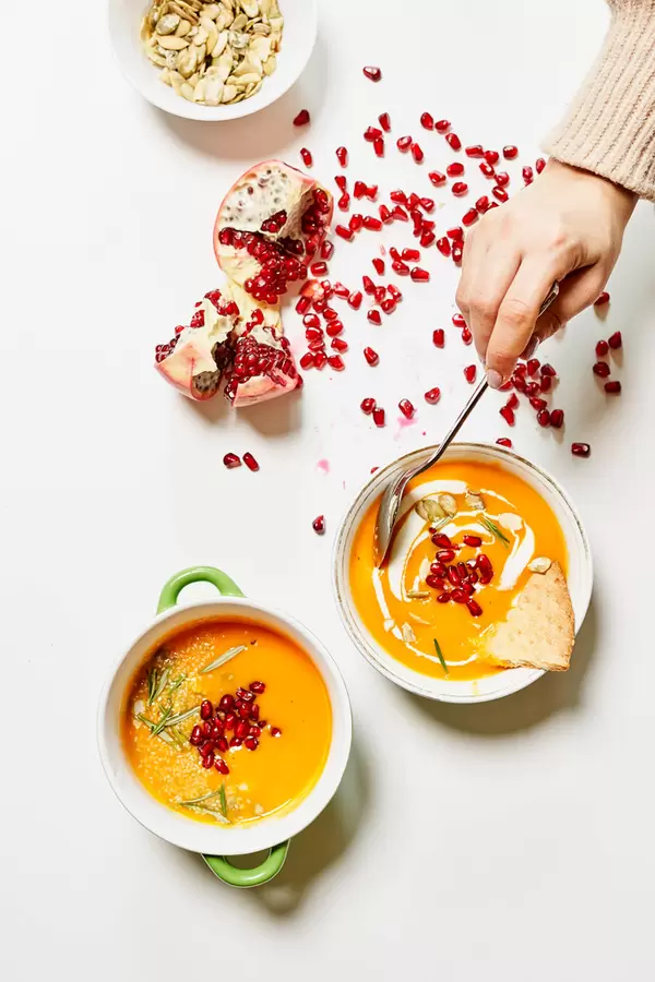 pumpkin soup served with squash and pomegranate seeds