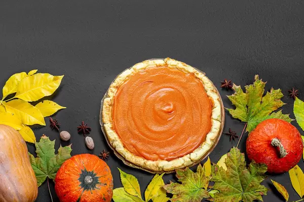 Pumpkins with yellow leaves and pumpkin pie. Background for thanksgiving day