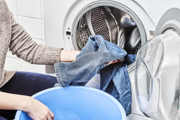 Putting jeans into the washing machine