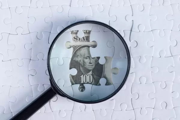 Puzzle and magnifier on money