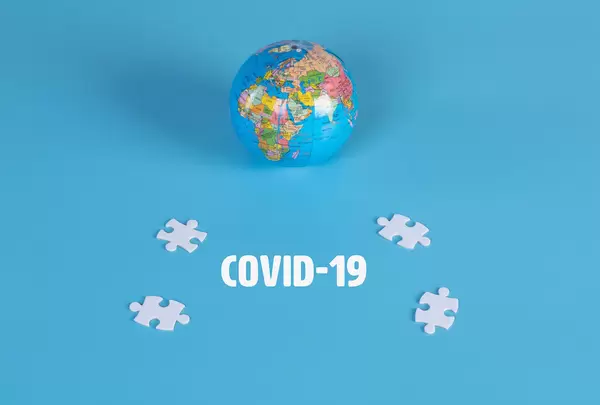 Puzzle pieces with globe and Covid-19 text