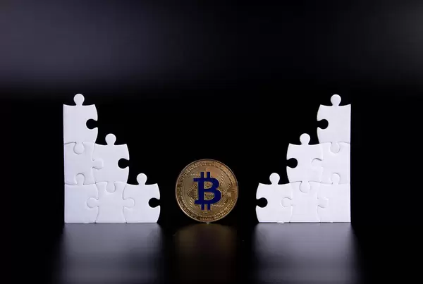 Puzzle pieces with golden Bitcoin coin on black background