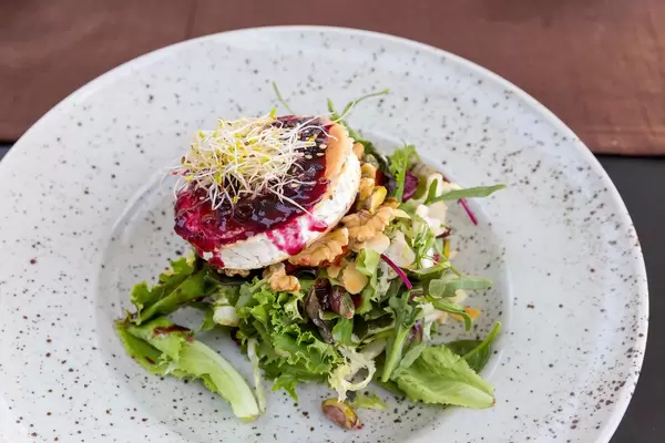 Q11, Pollença: gegrillter Ziegenkäse, Salatmischung, Pistazie, Walnüsse, Sesam, rote Früchte Dressing