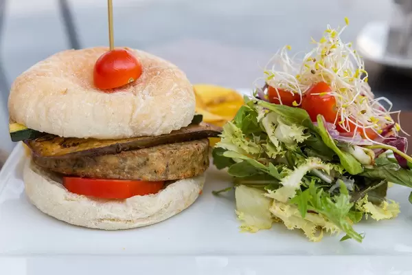 Q11, Pollença: veggie burger with tomato, pickled aubergine and zucchini, served with salad and fries