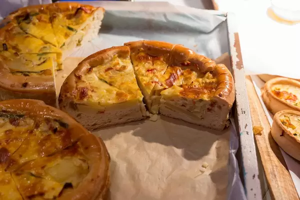 Quiche mit Kartoffeln, Zwiebeln und Paprika in runder Form als Snack auf der Digital X