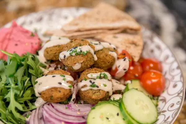"Falafel Bowl" im Fit Kitchen mit Tahini, Tsatsiki, Fetakäse, Tabouleh, Kalamata-Oliven, Spinat und Pitabrot, in Barcelona, Spanien
